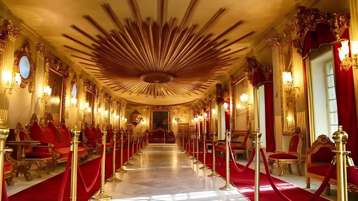 Gilded ceremonial hall at Abdeen Palace, Cairo, red velvet chairs flanking a roped carpet runner to the throne