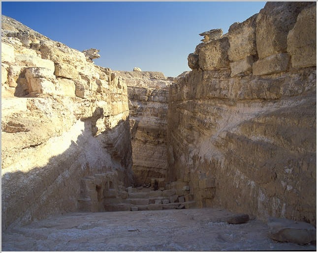 Ruined base of the Djedefre Pyramid at Abu Rawash, with surrounding rocky terrain.