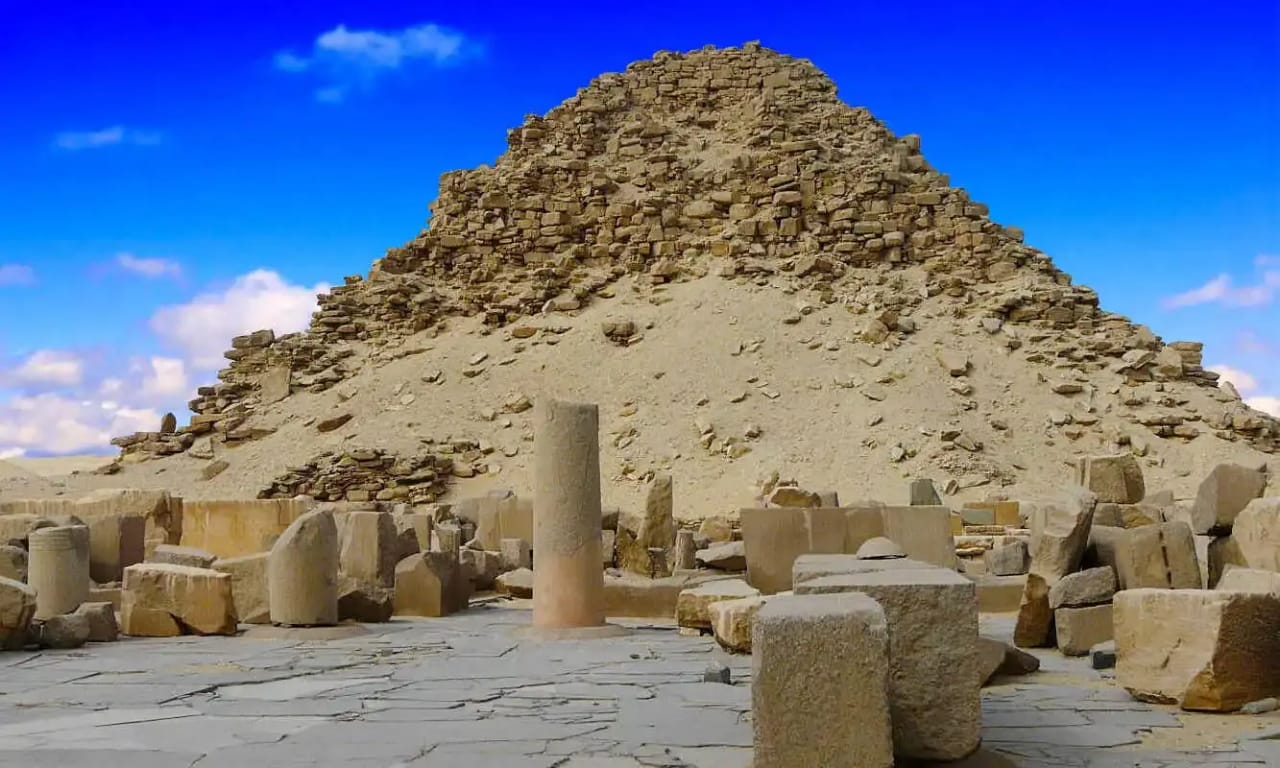 Ruins of the Pyramid of Sahure at Abusir with surrounding temple remains under a blue sky