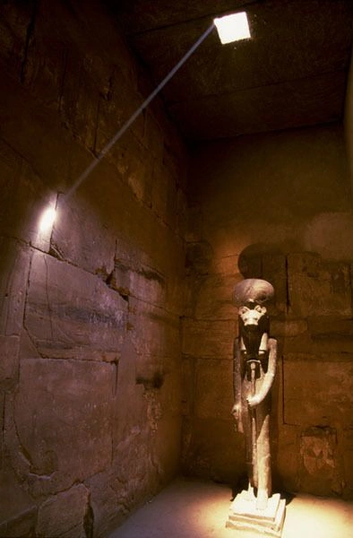 Sekhmet Karnak: a shaft of daylight from a roof slot crossing the dark chapel where the statue stands